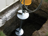 Installing a helical pier system in the earth around a foundation in Airdrie
